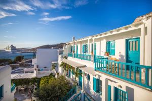a view of a building with blue balconies and the ocean at Pension Marias Sea View in Mikonos