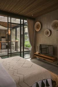 a bedroom with a large bed and a kitchen at Danu Villas Bali in Kerobokan