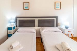 Dos camas en una habitación con paredes blancas. en La Farella La Coma 65 Apartamento con vistas mar, en Girona 15 fotos más