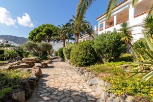 un camino frente a un edificio con palmeras en La Farella La Coma 65 Apartamento con vistas mar, en Girona