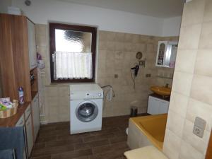 ein Bad mit einer Waschmaschine und einem Fenster in der Unterkunft Ferienwohnung Eurasburg im Loisachtal in Eurasburg