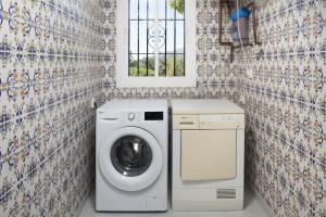 een wasmachine in een badkamer met een raam bij Villa Mimosa in Cómpeta