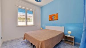 a bedroom with a bed and a window at Residence La Corte by Salento Affitti in Marina di Mancaversa