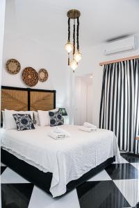 a bedroom with a large bed with white sheets and pillows at Georgia Pelekanou Studios in Fira