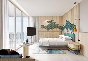 una camera con letto, tavolo e TV di Holiday Inn Pattaya, an IHG Hotel a Centro di Pattaya