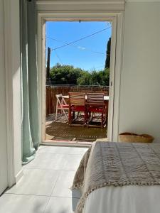 1 dormitorio con puerta que da a un patio con mesa en Maison au calme avec jardin et parking, proche de tout !, en La Ciotat