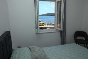 a bedroom with a bed and a window with a view at Exceptional Apartment Juniper, FIRST ROW TO THE SEA in Božava