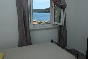 a bedroom with a window with a view of the water at Exceptional Apartment Juniper, FIRST ROW TO THE SEA in Božava
