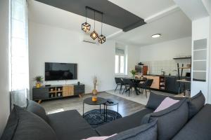 a living room with a couch and a kitchen at Exceptional Apartment Juniper, FIRST ROW TO THE SEA in Božava