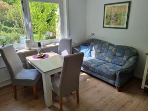 een woonkamer met een tafel en een bank bij Ferienwohnung Haseltal in Bad Orb