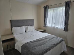 a bedroom with a large bed and a window at Castaways Holiday Park in Bacton