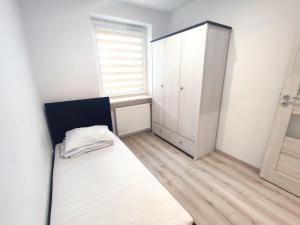 um pequeno quarto com uma cama e uma janela em Apartament Warneńczyka Mielec em Mielec