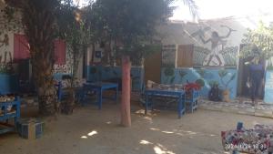 un grupo de mesas y árboles frente a una pared en Al Salam Camp en Luxor