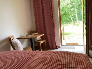 a bedroom with a bed and a table and a window at Teichland Linum Apartments in Fehrbellin