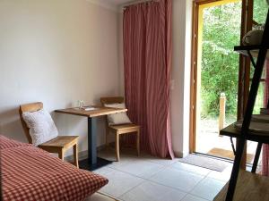 a room with a desk and a table and a window at Teichland Linum Apartments in Fehrbellin