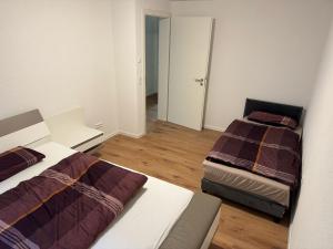 a small room with two beds and a hallway at Neues Apartment Ehingen 2.0 in Ehingen