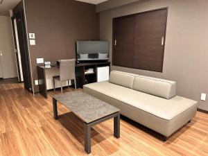 a living room with a couch and a table at Reftel Osaka Airport Hotel in Ikeda