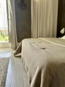 uma cama com um cobertor num quarto com uma janela em Côté Park em Givry
