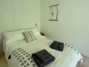 Una cama con dos bolsas sentadas encima. en Rock Pipit, Moor and Sea Holidays, five minutes drive to the sea, en Lynton