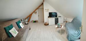 uma sala de estar com um sofá e uma televisão em Petit appartement à la campagne proche mer em Missillac
