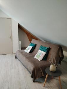 1 dormitorio con cama con almohadas y mesa en Petit appartement à la campagne proche mer, en Missillac