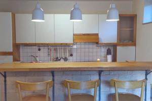 a kitchen with two chairs and a counter with white cabinets at Seaside Serenity House in Piran