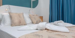 Una cama con toallas blancas y almohadas. en Sun and Moon Villas en Aliko Beach