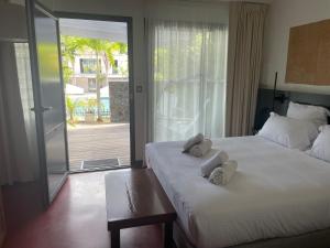 una camera d'albergo con due letti e asciugamani di Dimitile Hôtel & Spa a Entre-Deux