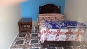 a small bedroom with a bed and a tiled floor at Al Salam Camp in Luxor