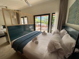 Un dormitorio con una cama con dos ositos de peluche. en Dimitile Hôtel & Spa, en Entre-Deux