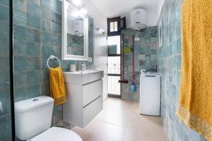 ein Badezimmer mit einem WC, einem Waschbecken und einem Spiegel in der Unterkunft Relax studio Primavera in Las Galletas