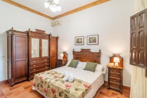 ein Schlafzimmer mit einem großen Bett und Holzmöbeln in der Unterkunft Casa Rural Azahares de Marchena in Marchena + 37 Fotos