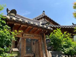 a wooden entrance to a building with a roof at Sarangroo in Jeonju