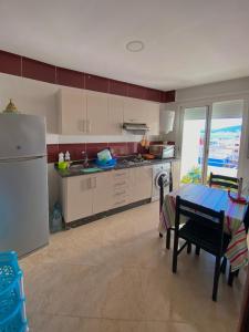 een keuken met een tafel en een koelkast bij Appartement près de la plage in Martil