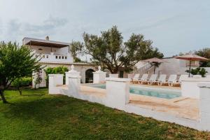 a villa with a swimming pool and a house at Masseria della Piana in Villanova di Ostuni