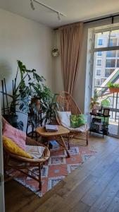 sala de estar con 2 sillas de mimbre y mesa en Kyiv Jungle apartment en Kiev