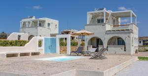 una casa con piscina, sombrilla y sillas en Sun and Moon Villas en Aliko Beach