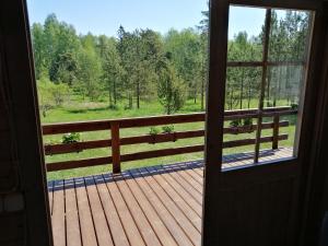 a door to a porch with a view of a forest at Rangi Suvemaja in Hiiumaa