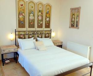 a large white bed in a room with two tables at Odysseion Apartments in Vathi