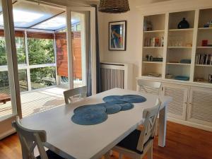 a dining room table with blue plates on it at Le Plongeoir in Donville-les-Bains +15 photos