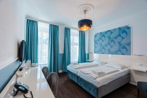 a bedroom with a bed with a blue painting on the wall at Hotel Prens Berlin in Berlin