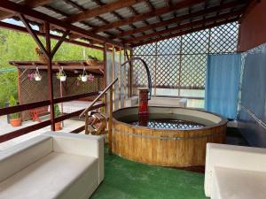 bañera de hidromasaje en una habitación con suelo verde en Pensiunea Maria, en Sovata