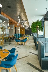 a dining room with blue chairs and tables at Rest&Ski Spa Resort in Bukovel