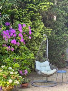 uma cadeira de baloiço sentada num jardim com flores em Holiday Home 'Beautifull Water' em Lanaken