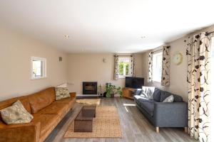 a living room with a couch and a tv at Gwithian Holidays in Hayle