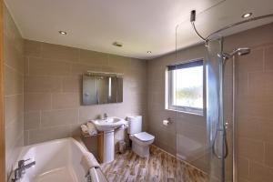 uma casa de banho com um lavatório, um WC e um chuveiro em Gwithian Holidays em Hayle