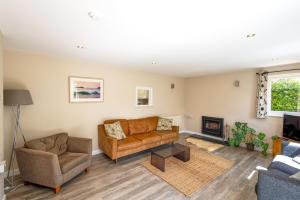 a living room with a couch and a fireplace at Gwithian Holidays in Hayle