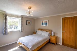 a bedroom with a bed and a window at Gwithian Holidays in Hayle