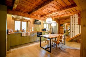 a kitchen with a table and chairs in a room at Sowie Domki - Domek Nad Potokiem in Kacwin