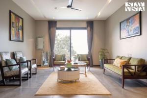 a living room with a couch and a table at StayVista at Barkat Villa with Jacuzzi in Rāmgarh
